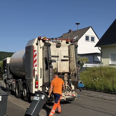 M&uuml;llwerker zieht Tonne zum M&uuml;llsammelfahrzeug